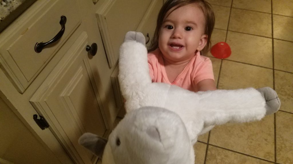Mama Rissa's daughter holding stuffed animal out to mommy. 