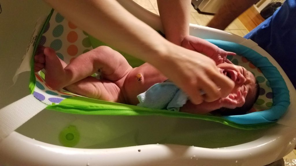 Mama Rissa's baby in a baby bath showing how to bathe a newborn.