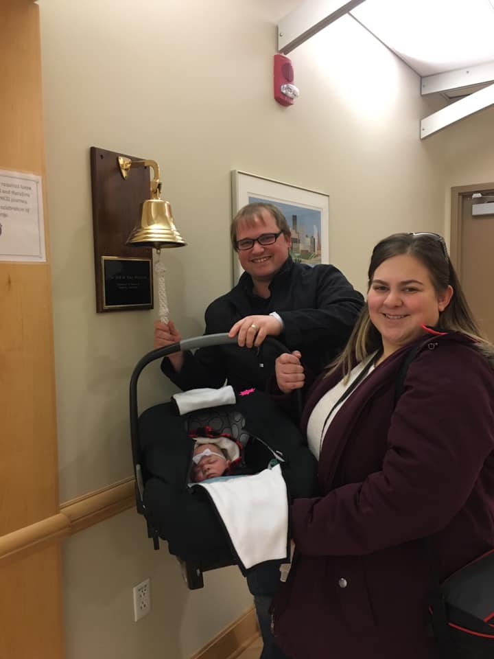 Katie and her husband leaving the hospital with their daughter.