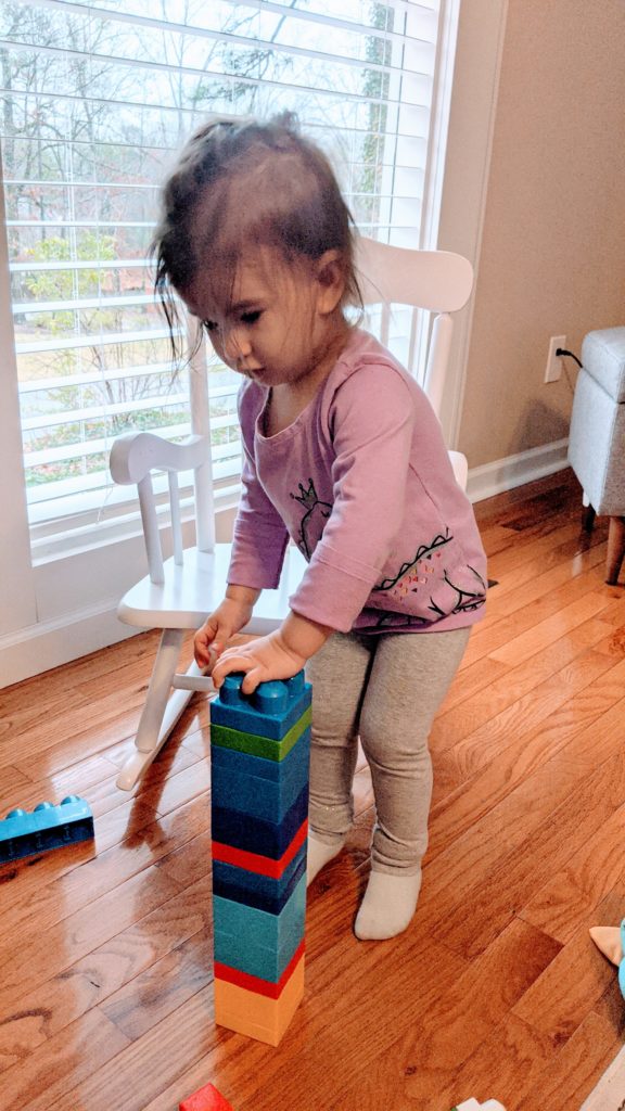 Mama Rissa's daughter building a block tower.