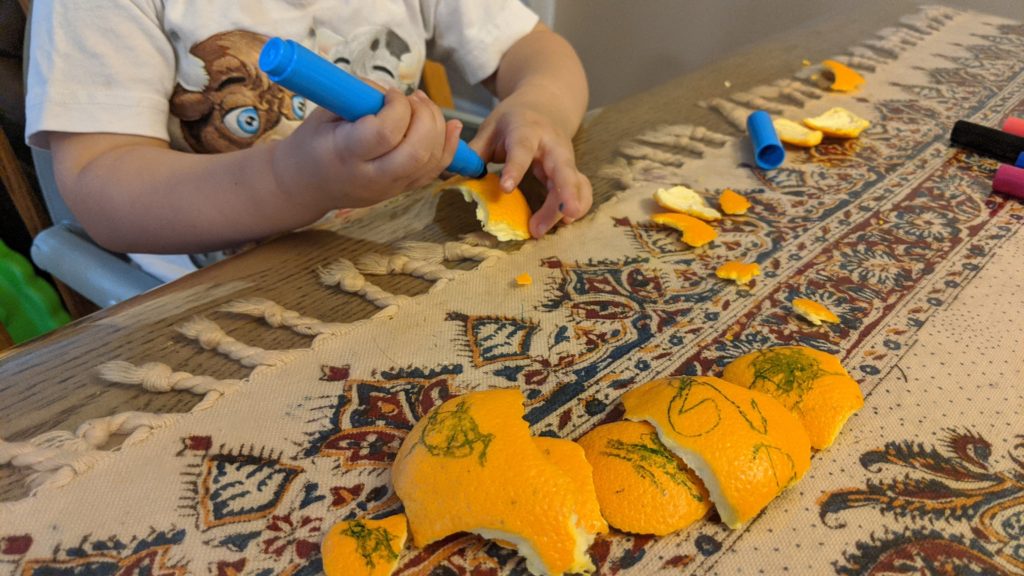 Mama Rissa's daughter coloring orange peels.