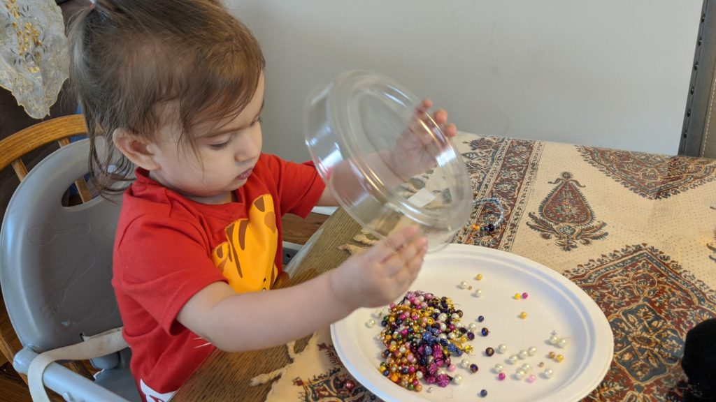 Mama Rissa's daughter dumping beads.