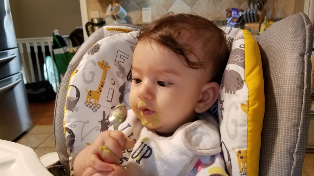 Mama Rissa's daughter eating off of a spoon while learning how to start solids.