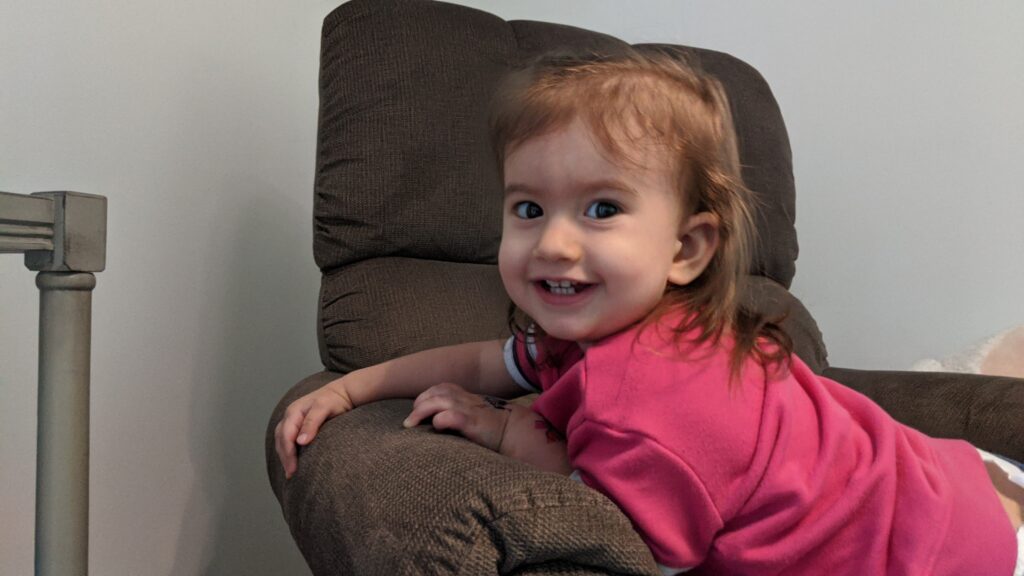 Mama Rissa's daughter playing happily on a chair.