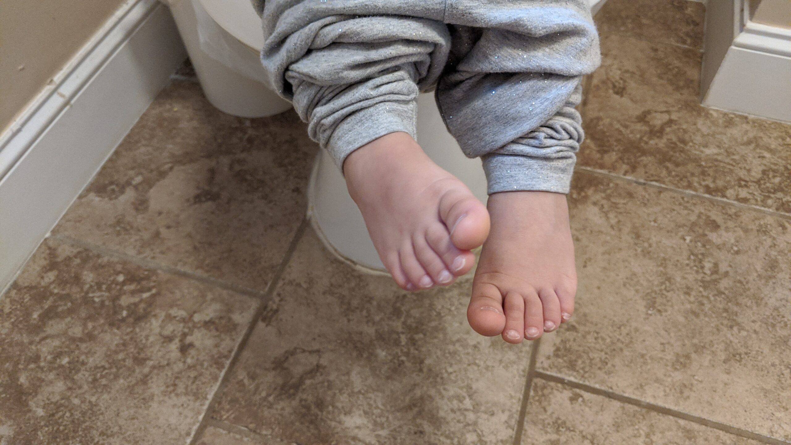 Mama RIssa's daughter's feet hanging over the potty while potty training.