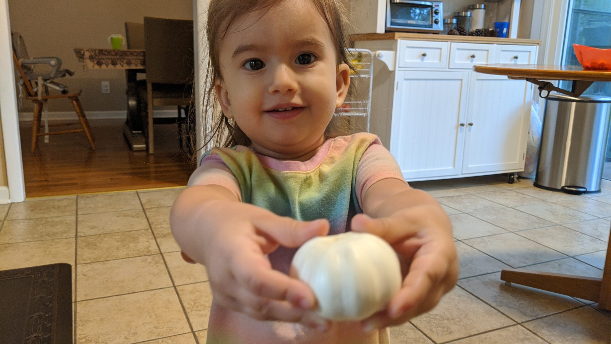 Mama Rissa's daughter holding a head of garlic